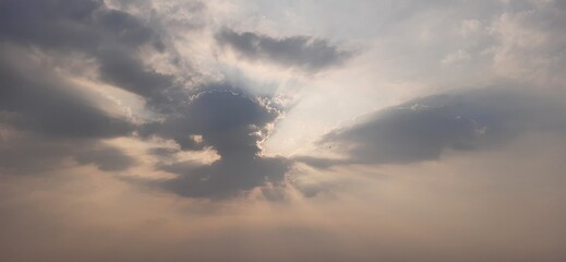 Hidden sun in dark cloud over sea