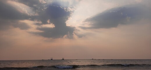 Hidden sun in dark cloud over sea