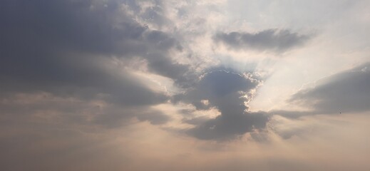 Hidden sun in dark cloud over sea