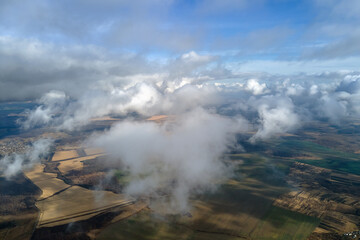 Aerial view from high altitude of earth covered with puffy rainy clouds forming before rainstorm
