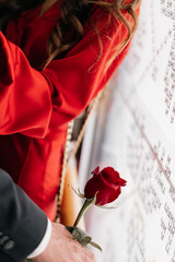 photograph with focus on red rose during man and woman hugging