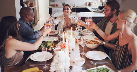 Gather your friends and let the good times flow. Shot of a group of young friends toasting with wine at a Christmas dinner party.