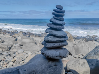 Pyramid of grey pebbles on a Madeira island beach on the shore of Atlantic ocean