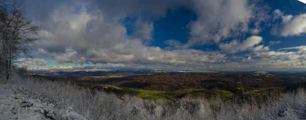 Wide panorama looking from Ostri vrh towards beautiful Radensko polje close to Grosuplje, Slovenia. Snow on the top, while green meadows at the bottom.
