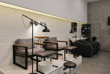 Interior of the beauty salon with nail zone with chairs, lamps and backwashes.