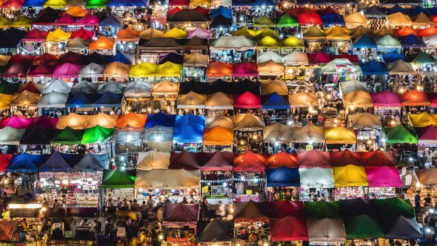 Time lapse view of colourful food stalls at the popular Ratchada Night Market in Bangkok, Thailand.	
