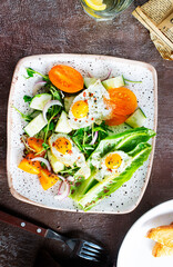 fried eggs with vegetables, top view, diet salad with quail eggs