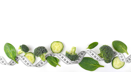 Green vegetables and a measuring tape on a white background.Healthy lifestyle concept. Diet...