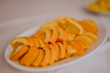 Cytryny, pomarańczki i limonki na białym talerzu  - obrazy, fototapety, plakaty