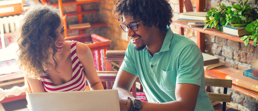 Woman and man students studying in the coffee shop using laptop