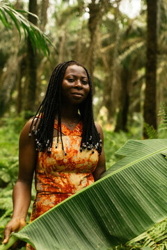 portrait of a african female nature activist holding a plant 