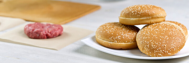 cheeseburger and beefburger ingredients. bun and raw burger cutlets. Burger bbq party. close up
