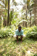 Portrait of a black african nature activist placing his hands in the soil 