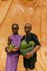 Fototapeta premium Portrait of a pair of young nature activists holding their fresh fruit harvest crop 