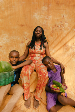 Family portrait of black african farmers standing in front of a orange background