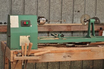 Old wood lathe and tools in shed - obrazy, fototapety, plakaty