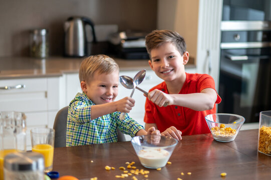 Two joyous kids enjoying their morning meal