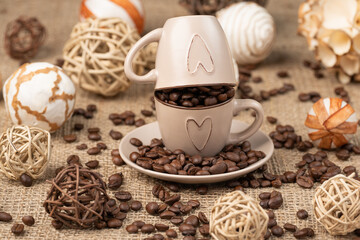 Cup full of coffee on burlap, 
scattered coffee on burlap.   - obrazy, fototapety, plakaty