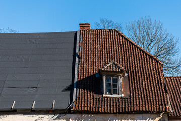An old, historic house, which is partially undergoing roof repairs, Kuldiga, Latvia.