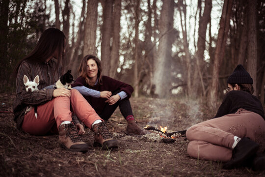 natural looking alternative friends relax in nature around fire