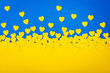 Ukrainian flag made of blue background and yellow hearts. Papercut concept of ukrainian motive.