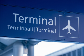 Closeup of an airport sign with word terminal in english, finnish and swedish