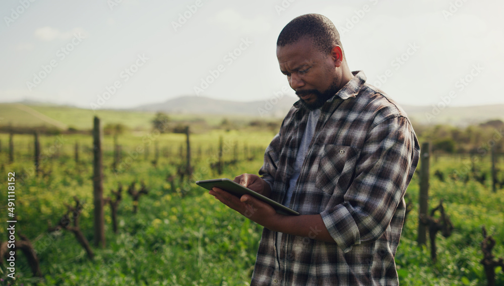 Aufkleber farming just got a whole lot more efficient. shot of a mature man using a digital tablet while worki