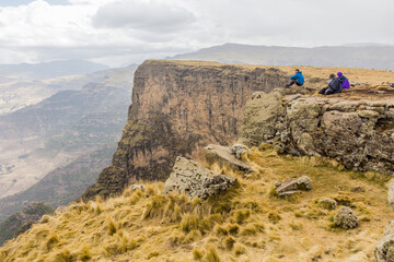 SIMIEN MOUNTAINS, ETHIOPIA - MARCH 16, 2019: Tourists looking into the northern escarpment in Simien mountains, Ethiopia