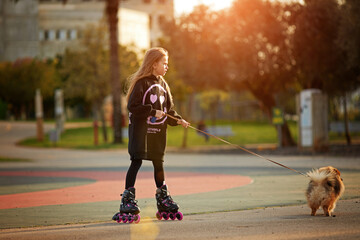 girl rollerblading with a dog in the park