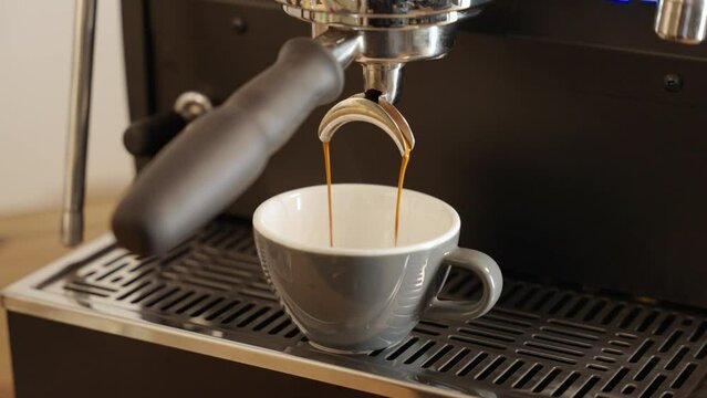 fresh coffee is poured into cup from coffee machine 2