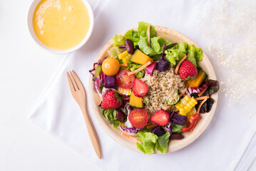 Fresh mixed fruits and vegetables salad in natural plate on white background, Healthy vegan food, Top view