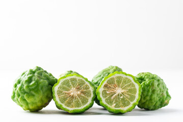 Organic Kaffir lime, Citrus fruit used in Southeast Asian cuisine and essential oil on white background