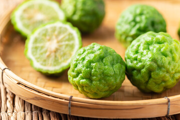 Organic Kaffir lime in bamboo basket, Citrus fruit used in Southeast Asian cuisine and essential oil