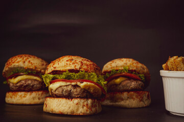 Three mini burgers on black background