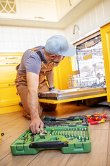 A man repairs a dishwasher