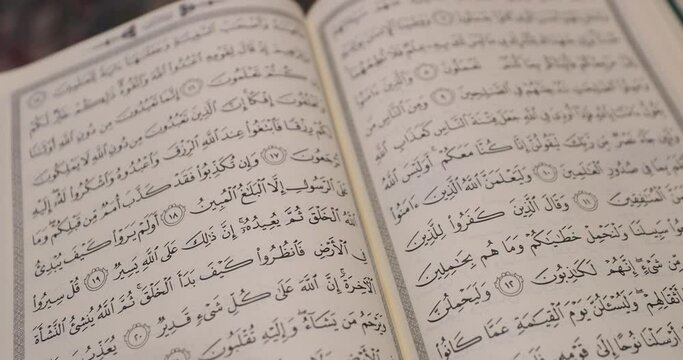 A shot of a beautiful opened Quran, the shot is slightly moving away