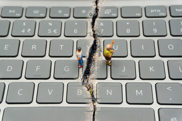 Internet Confrontation.digital divide.The keyboard is split by the cracks that separate the...