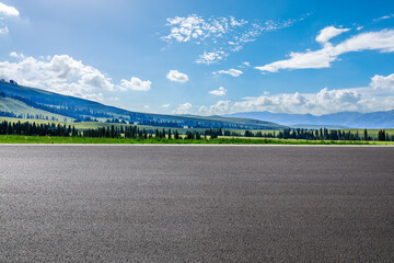 Empty asphalt road and green mountain nature scenery under blue sky. Road and mountains background.