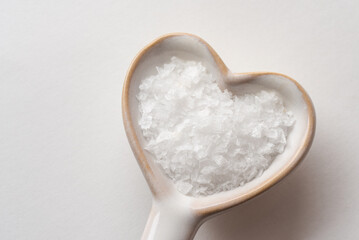 Fototapeta na wymiar Sea Salt Flakes on a Heart Shaped Spoon