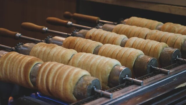 Close up footage of several trdelnik cakes being backed