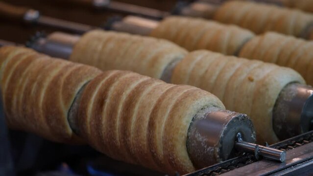 Footage of several trdelnik cakes being backed