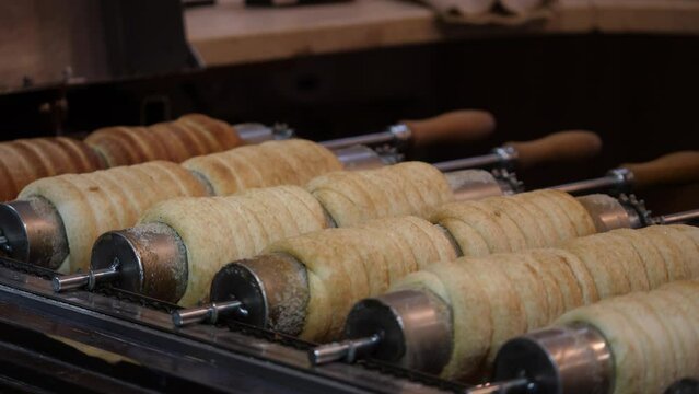 Footage of several trdelnik cakes being backed