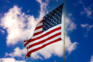 American flag against a blue sky with clouds