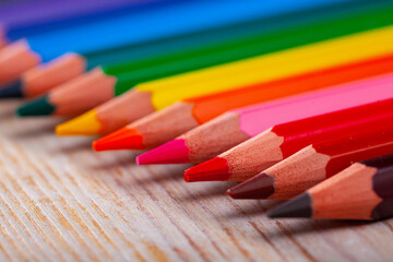 Fototapeta premium Image of multicolored wooden pencils on wooden surface