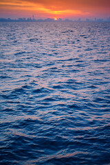 beautiful landscape of blue sea with skyline city background at sunrise