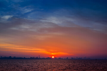 beautiful landscape of blue sea with skyline city background at sunrise