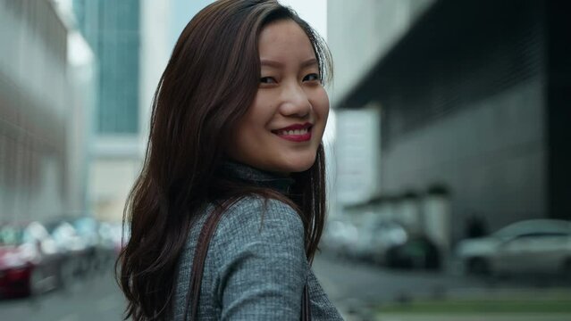 Young Chinese Girl Walking Casually in Street outdoors, Blinking and Glance back with Smile Happily at Daytime in Chengdu Sichuan China
