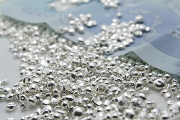 Money in the form of a cash banknote and precious metal, precisely sterling silver which is important in stocks, jewelry and industrial use and gets expensive during crisis. 