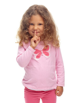 Ssh, I wont tell if you dont. Cute little girl making a ssh gesture against a white background.