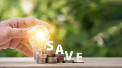 Man holding light bulb and many growth stack coins with plant in front and with the word save. concept saving money for finance accounting and idea for growing saving money.